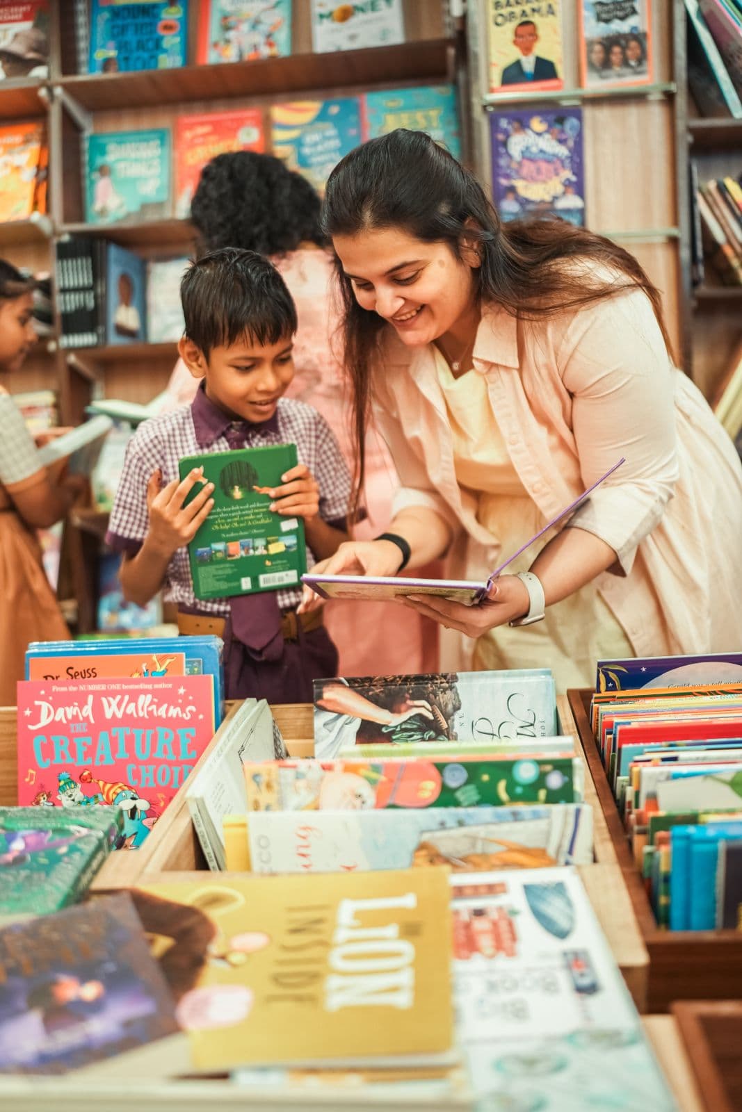 Gargi Sandu helping a student pick out a book from a bookstore display during a Mumbai Bookies outing