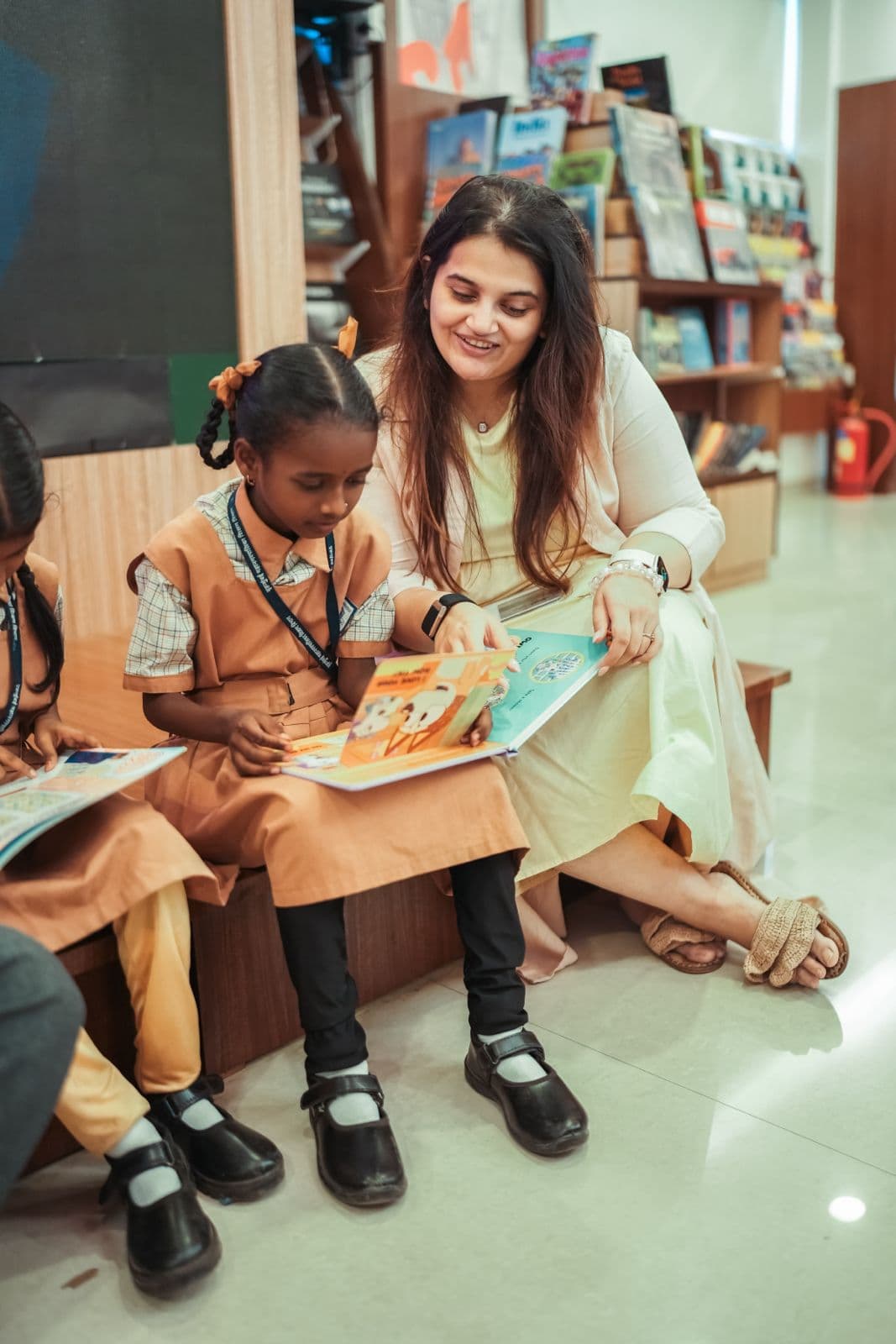 Gargi Sandu reading a picture book with a young schoolgirl at a Mumbai Bookies session